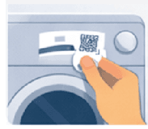 Hand placing a JustTaggit QR sticker on a washing machine